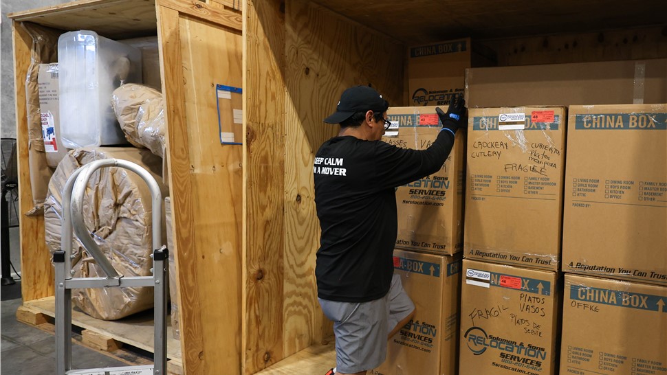 Custom wooden moving crates protecting furniture and fragile household belongings for transport.