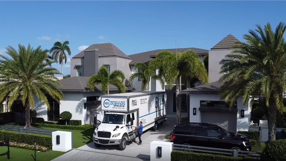 Moving truck parked outside a large home during a residential moving service.