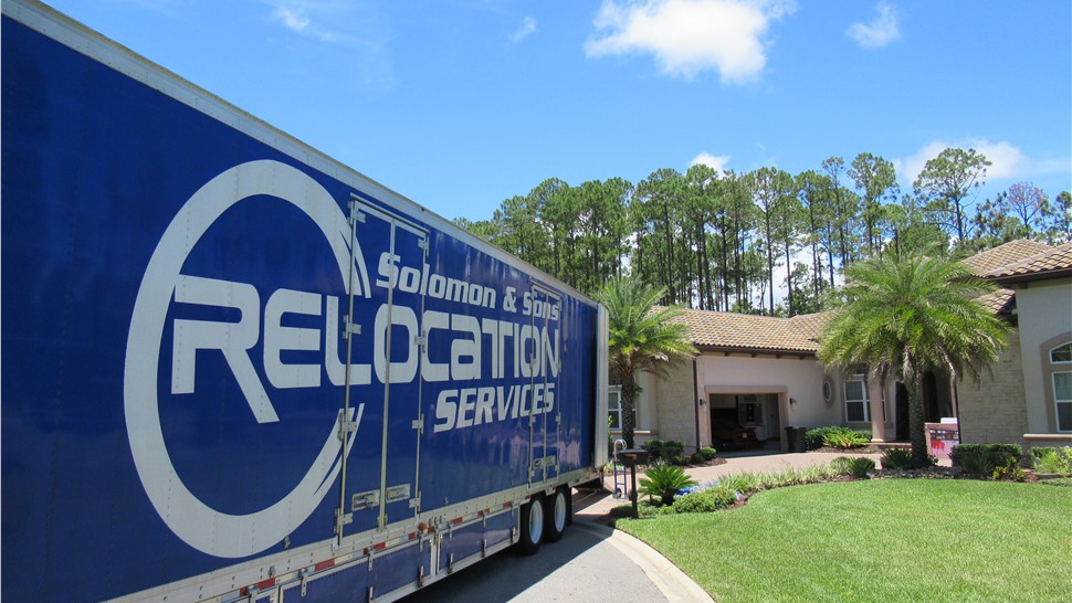 Solomon & Sons Relocation Services moving truck parked outside a luxury Florida home during a residential move.