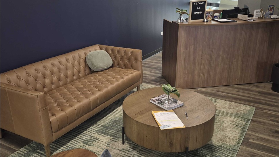 Reception area with sofa, chairs, table, and front desk after a Denver office relocation by Solomon & Sons.