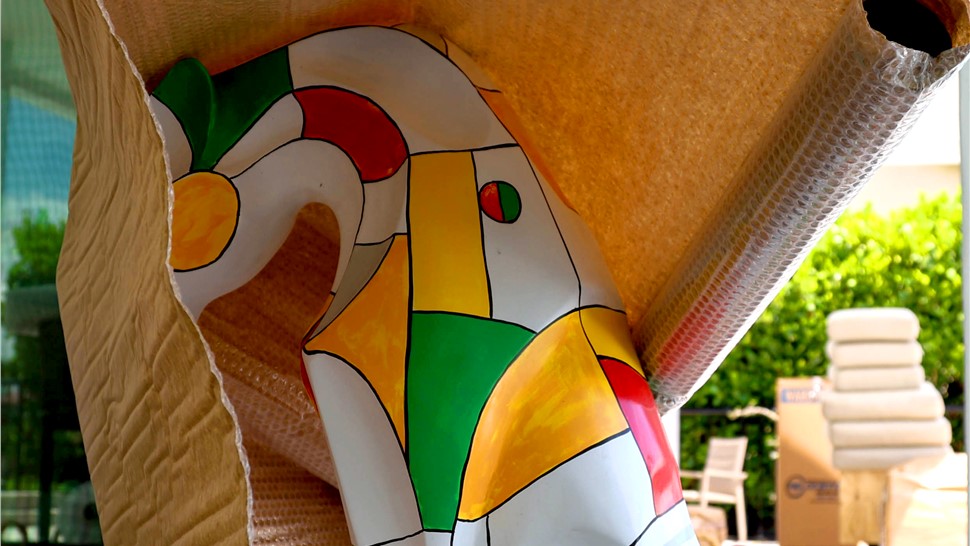 Colorful artwork partially covered with moving blanket and bubble wrap for protection.