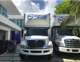 Two Solomon & Sons moving trucks parked at a modern Florida home during a residential move.