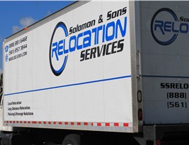 Solomon & Sons Relocation Services moving truck parked outside, showing company branding and contact information.