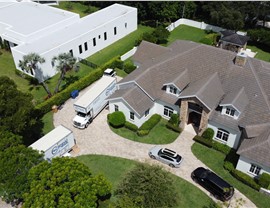 Aerial view of a large home with Solomon & Sons moving trucks parked outside during a residential relocation.