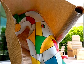 Colorful artwork partially covered with moving blanket and bubble wrap for protection.