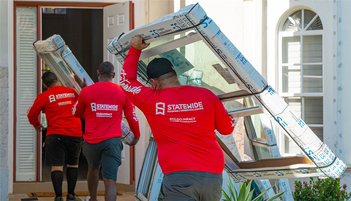 A team of window and door installation experts working on a home.