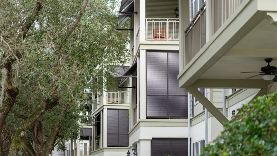 Motorized hurricane screens installed on a multi-story South Florida condominium providing storm protection, privacy, and solar control for balconies and outdoor living spaces.