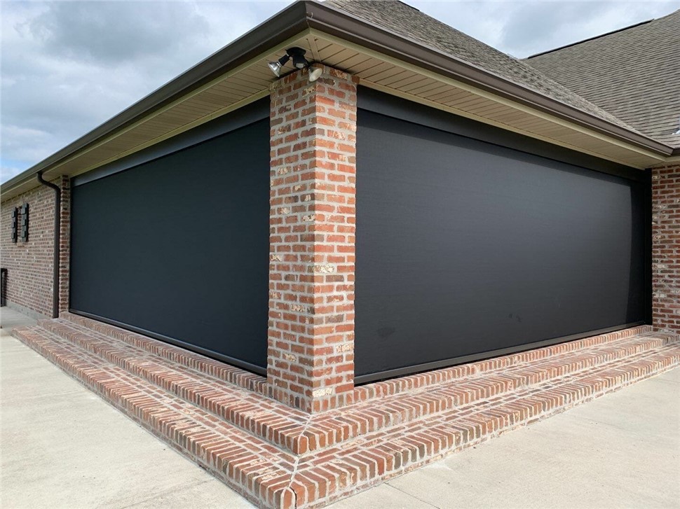 Motorized roll down screens enclosing a covered brick lanai