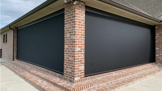 Motorized roll down screens enclosing a covered brick lanai