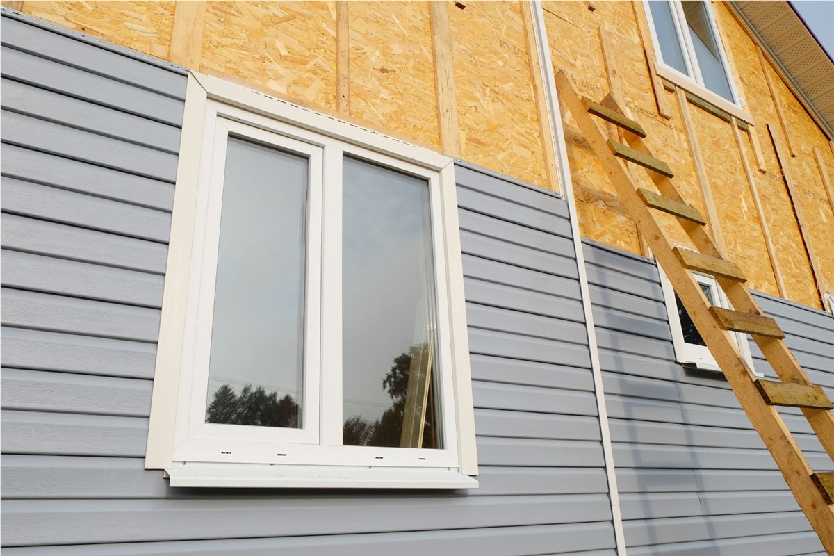 Siding being installed on the side of a house