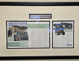 A framed article from June 2006, titled "All in Good Time," detailing a challenging roofing project completed by The Roofing Co. Inc. on the Christian Broadcast Network (CBN) building.