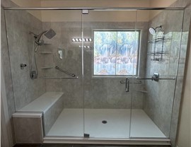 Glass shower remodel by Thompson Bath with marble-look walls, safety grab bars, and modern shower fixtures for Las Vegas and St. George homeowners.