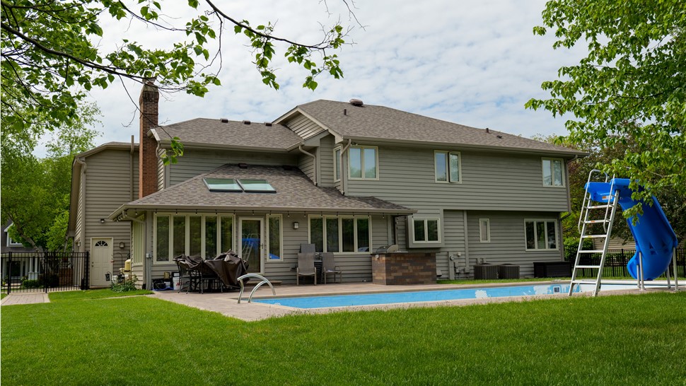 "The image captures the exquisite beauty and durability of Owens Corner Driftwood Shingles adorning a roof, blending seamlessly with the surrounding architecture."