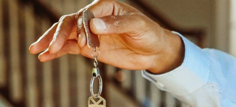 Hand holding house keys during San Jose relocation