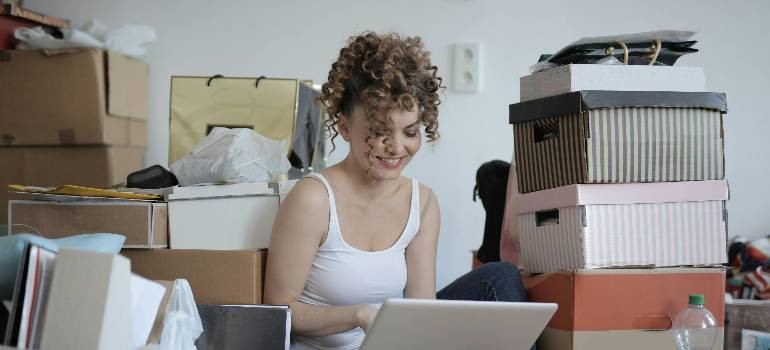 Woman sorting boxes while planning moving to the big city.