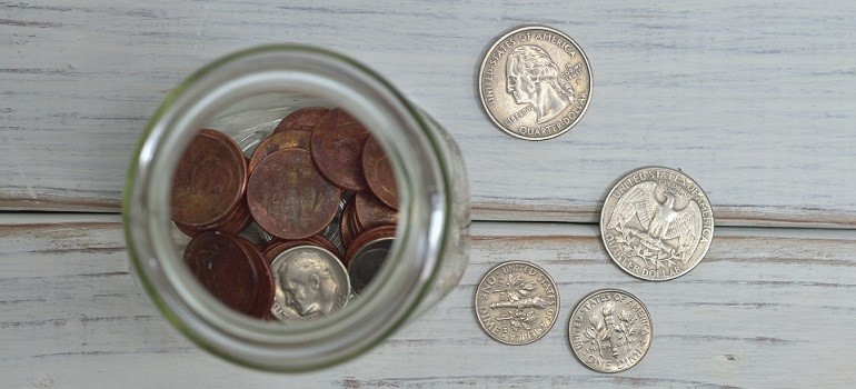Loose coins and jar showing moving budget planning