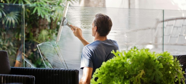 A man cleaning windows to move to the Bay Area this spring