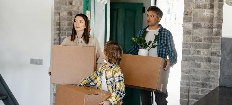 Family carrying boxes into new Fremont home after local move