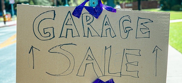Garage sale sign on street pole during sunny day