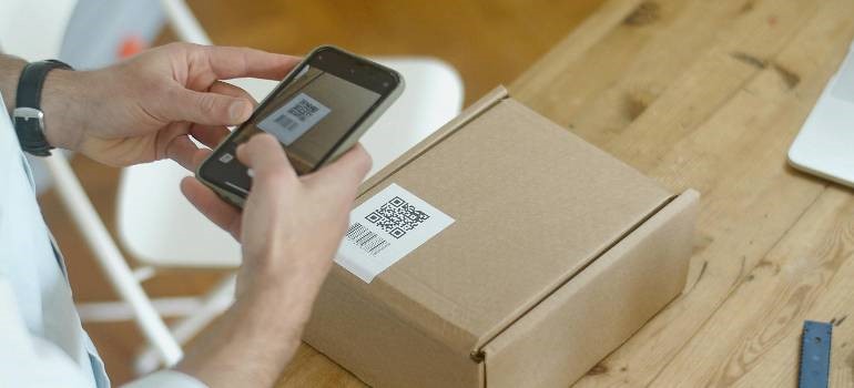 Person scanning QR code on a package like super organized people do before moving day