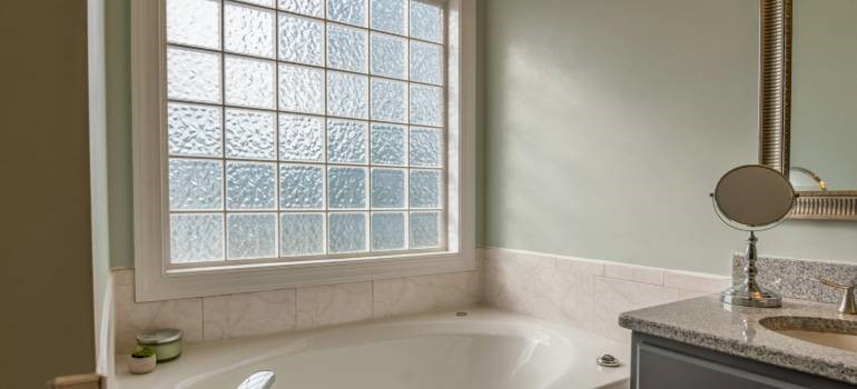 Bathroom with bathtub and glass block window