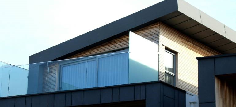 Modern house exterior with balcony and glass railing