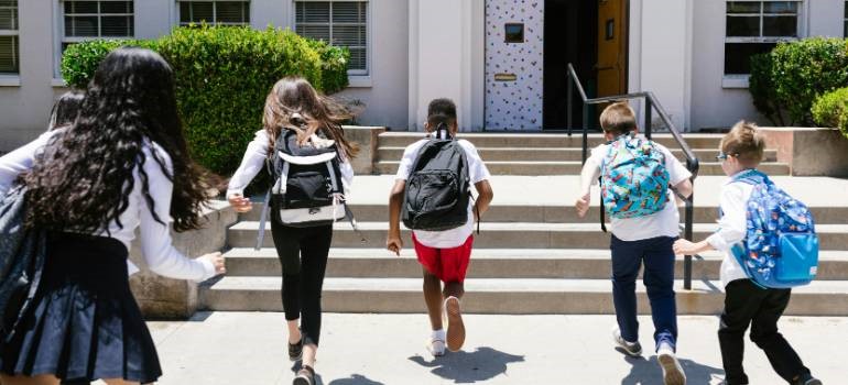 Children running into a school building entrance.
