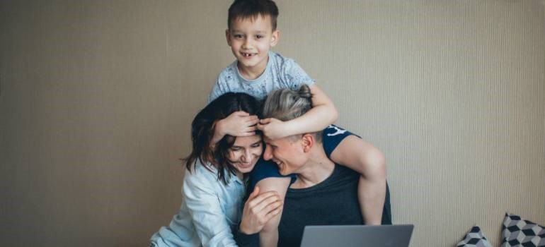 Family smiling together while using laptop at home in one of the top locations in the Bay Area for remote workers