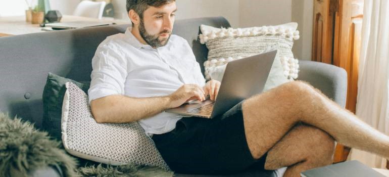 Man working from couch with laptop in living room in one of the top locations in the Bay Area for remote workers