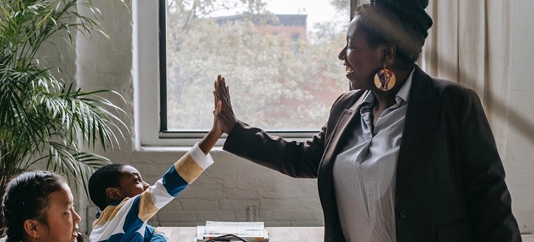 Teacher high-fiving student in classroom