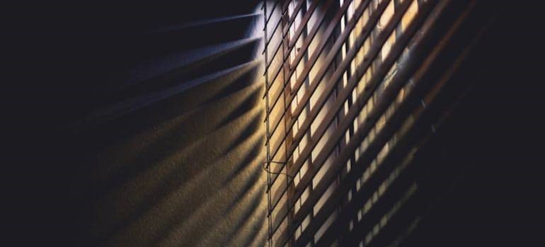 Closed blinds blocking sunlight during a hot day