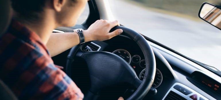 Man driving a car during the day