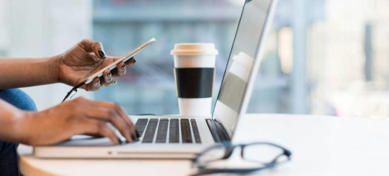 a cup of coffee next to a laptop