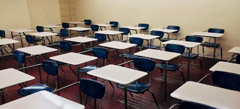Empty classroom with rows of desks for students whose parents navigated  challenges of moving to East Bay