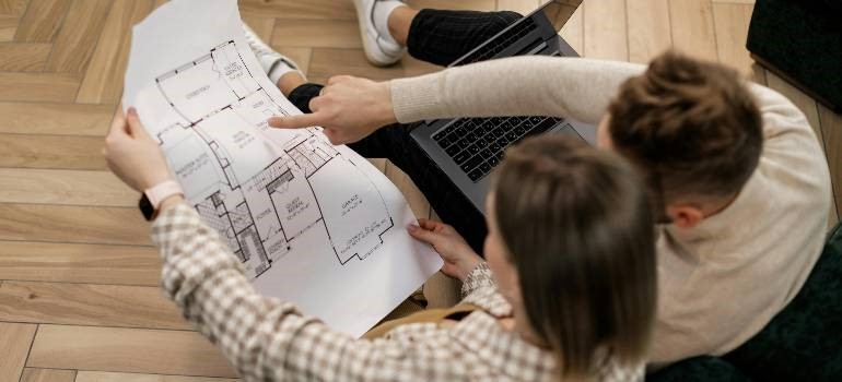 A couple reviewing house blueprints while planning their move