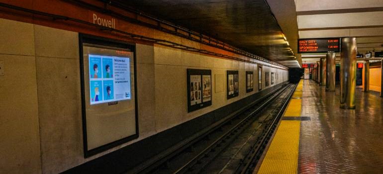 Subway station platform where people face cost of living in San Leandro vs Oakland.