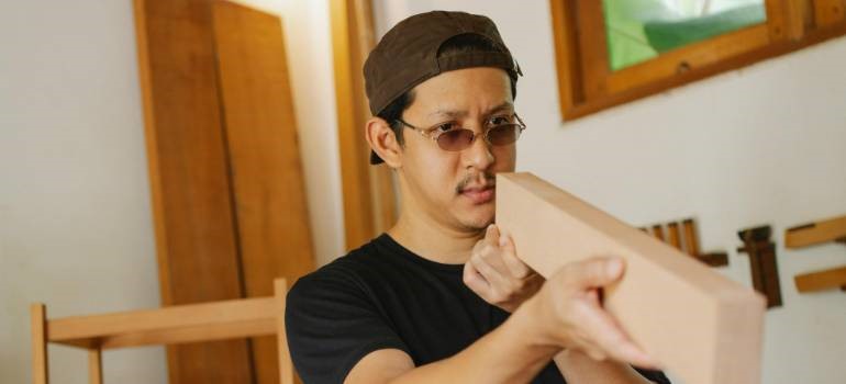 Man measuring wooden furniture piece