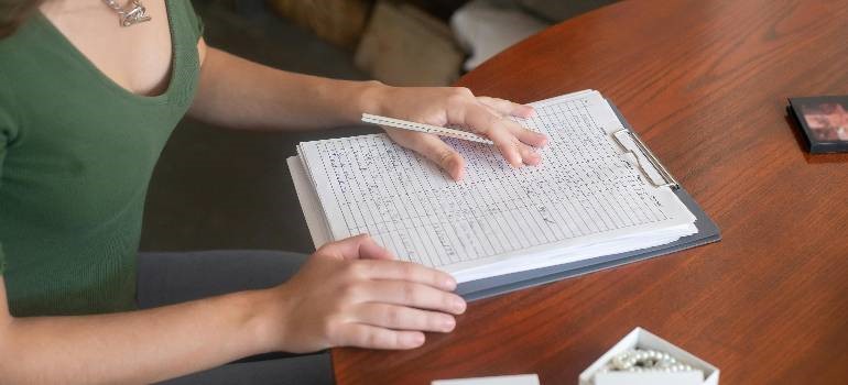 Person organizing an inventory to avoid mistakes people make when storing furniture long-term.