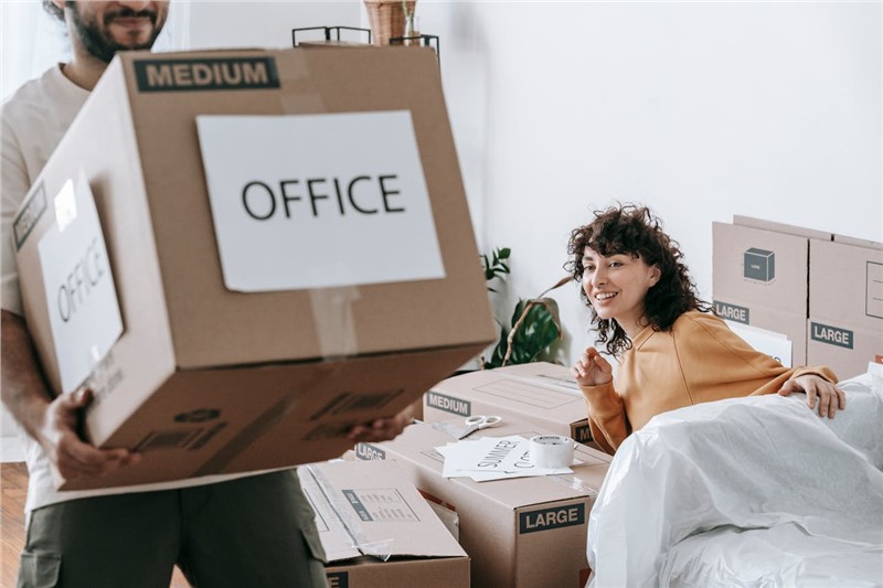 man holding a box and woman sitting