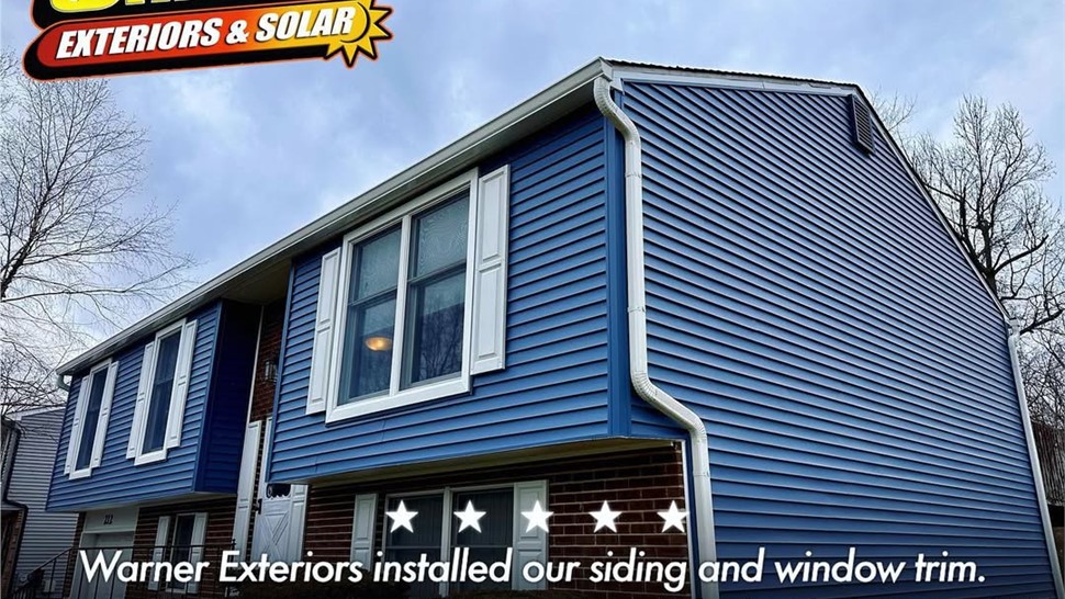 Customer review graphic showing blue home siding and window installation completed by Warner Exteriors.