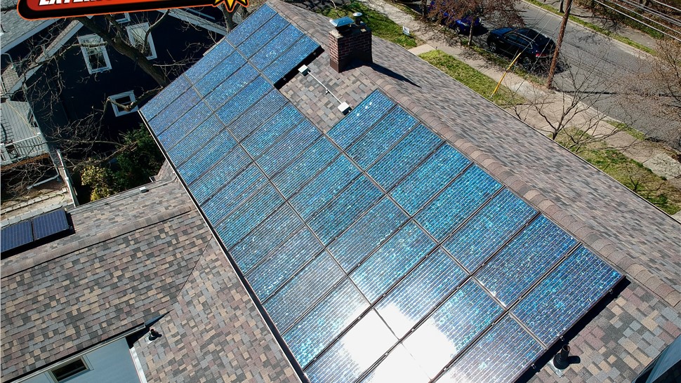 Solar panel array installed on a residential shingle roof in New Jersey shown from an elevated drone angle