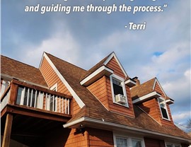 Close up of a home with cedar style siding and roofing featured in Warner Exteriors review graphic.