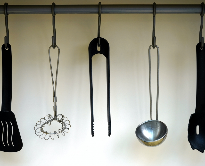 Organized kitchen utensils hanging from hooks