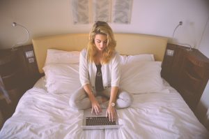 Woman getting a moving quote online from the comfort of her own bed.
