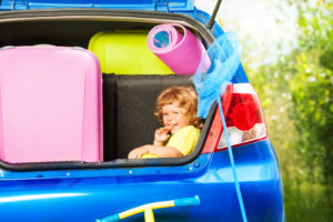 Make moving fun for kids - a young child waits in the car while parents load the car