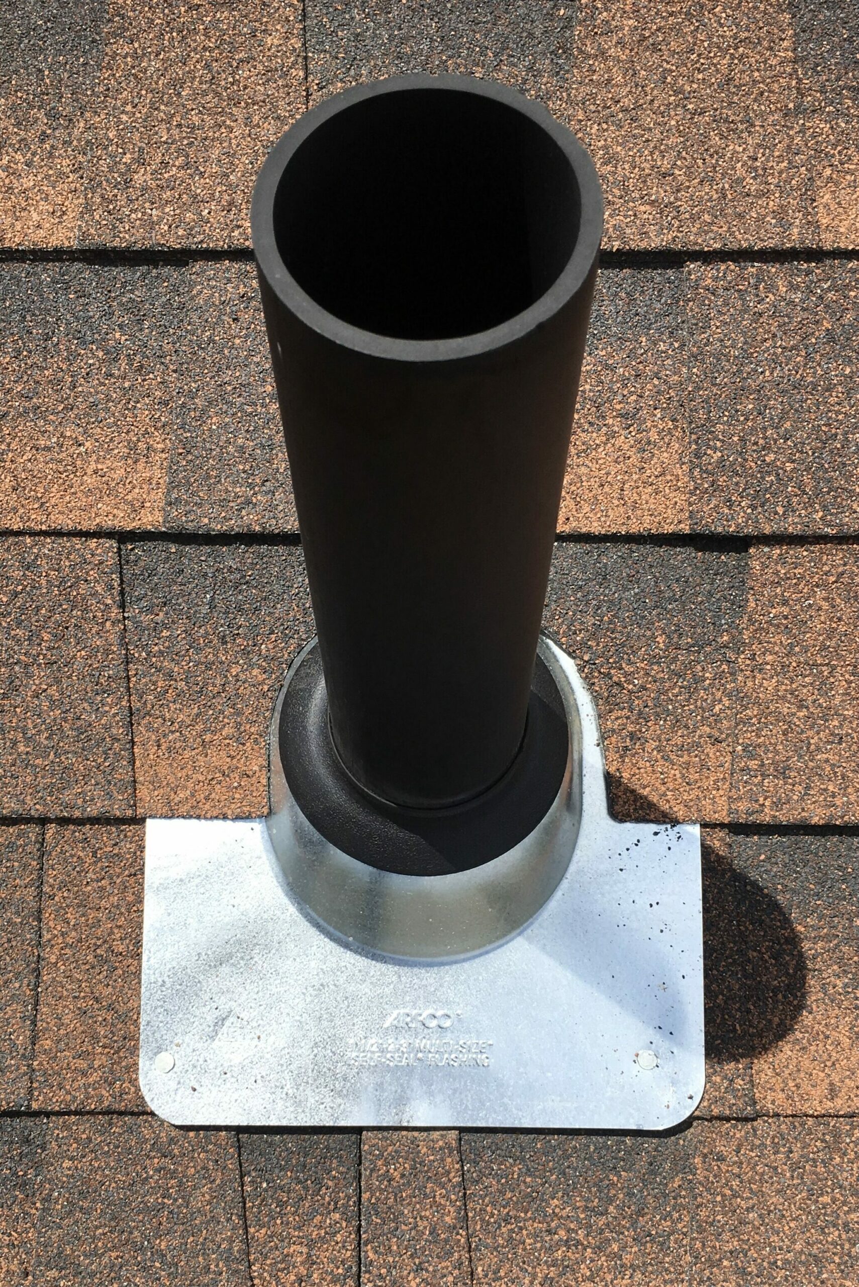 image shows a new pipe jack with new matching shingles on a boulder roof repair