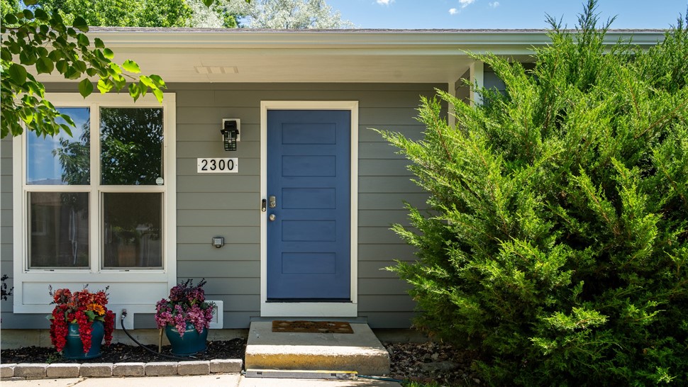 Front entry with navy blue Timbergrain fiberglass door and James Hardie Gray Slate siding in Longmont, CO
