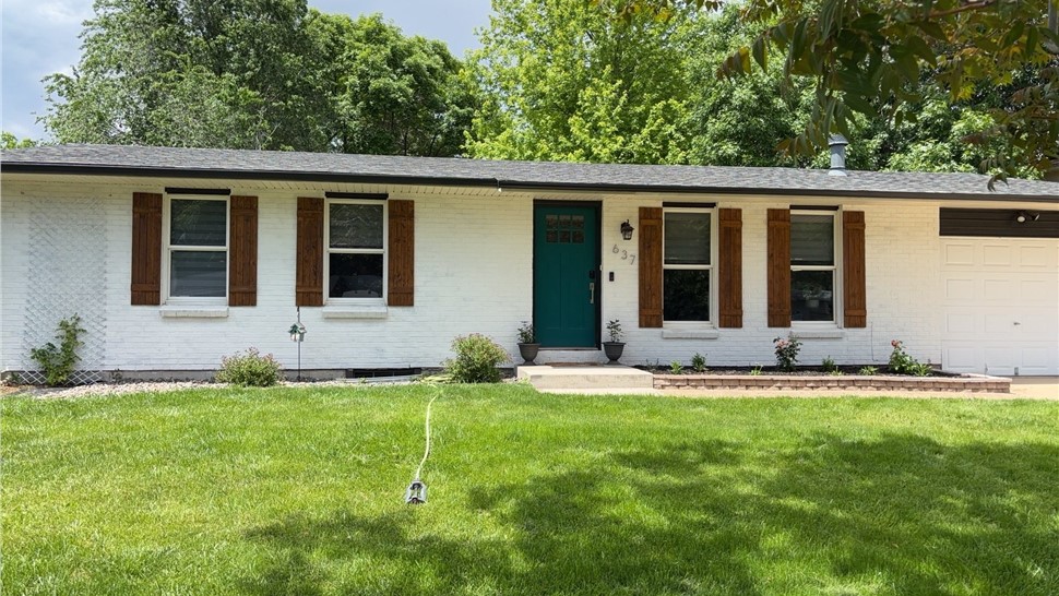 Front exterior of a white painted brick ranch home in Longmont before gable siding replacement