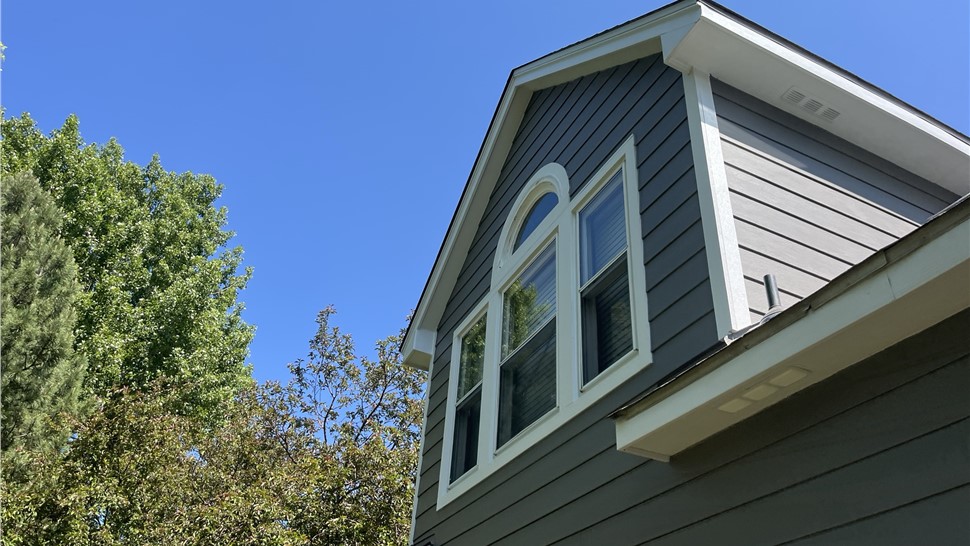 James Hardie siding and Arctic White trim around an arched dormer window in Fort Collins