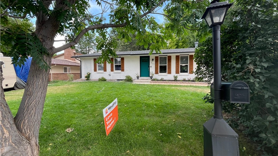 Front exterior of a white painted brick ranch home in Longmont after gable siding replacement